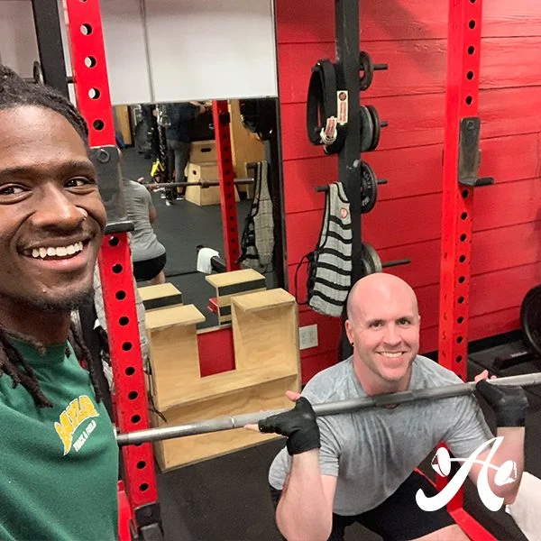 Client highlight Zach doing a front squat with his trainer
