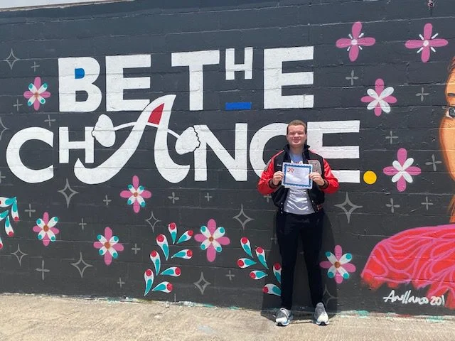 Recipient in front of mural