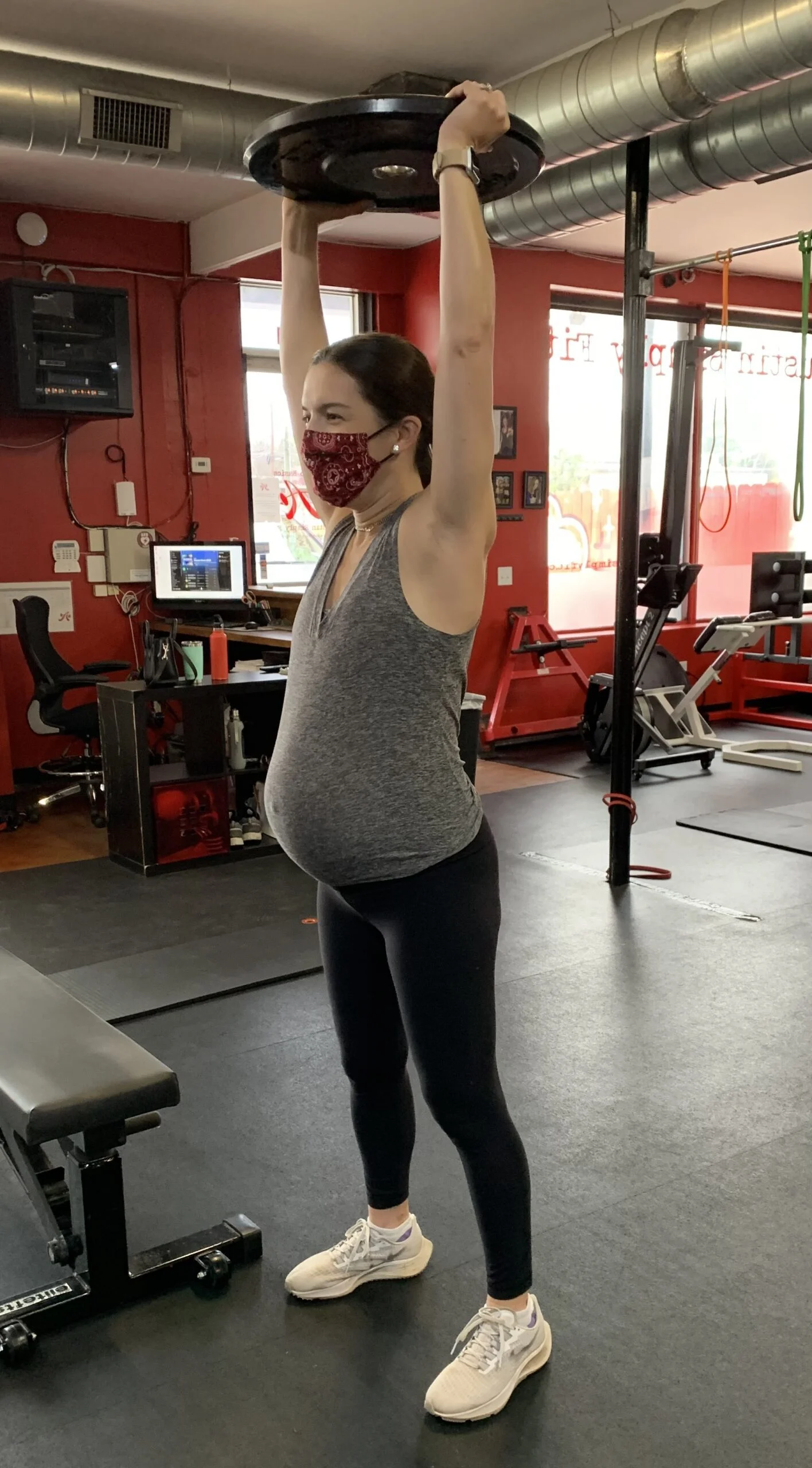Pregnant client lifting a plate above her head