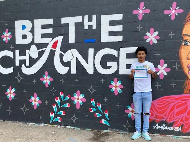 Recipient in front of mural