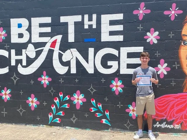 Scholarship recipient in front of mural