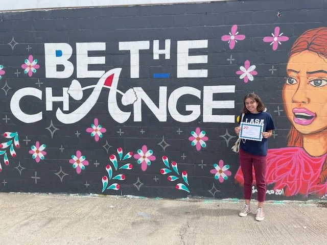 Recipient in front of mural