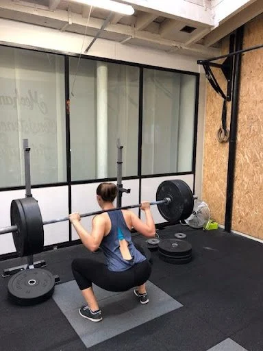 Client doing a barbell back squat
