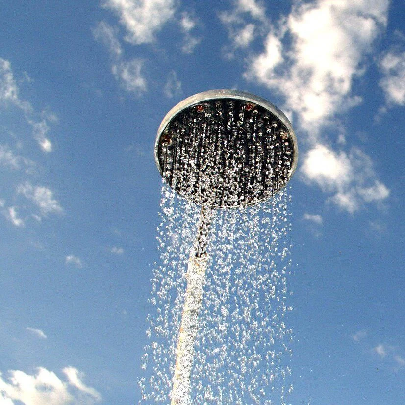water from a shower against a blue sky