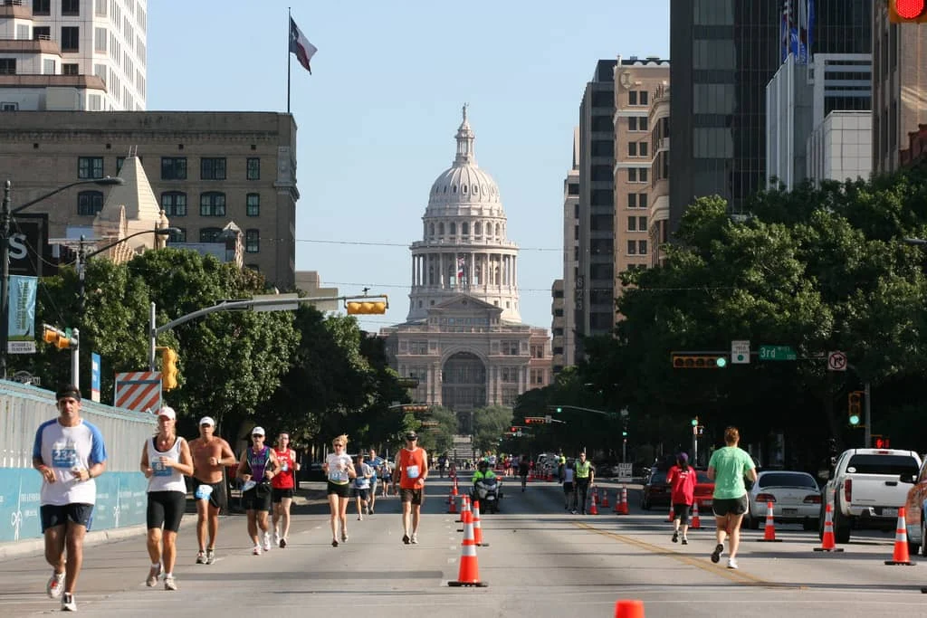 A view of the Texas Capitol while people exercise during a marathon