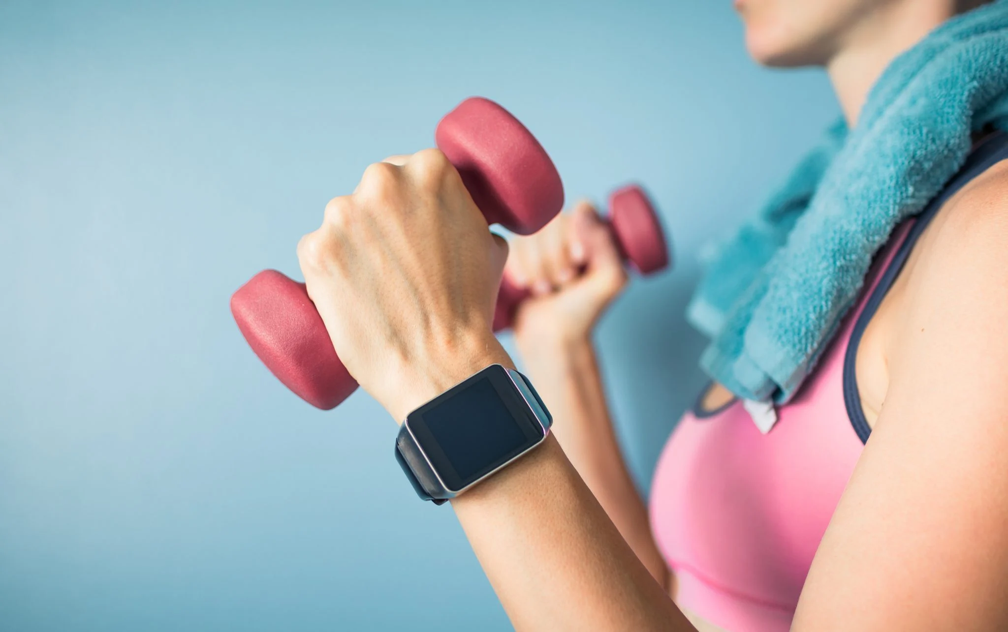 Wearable smartwatch on person holding dumbbells