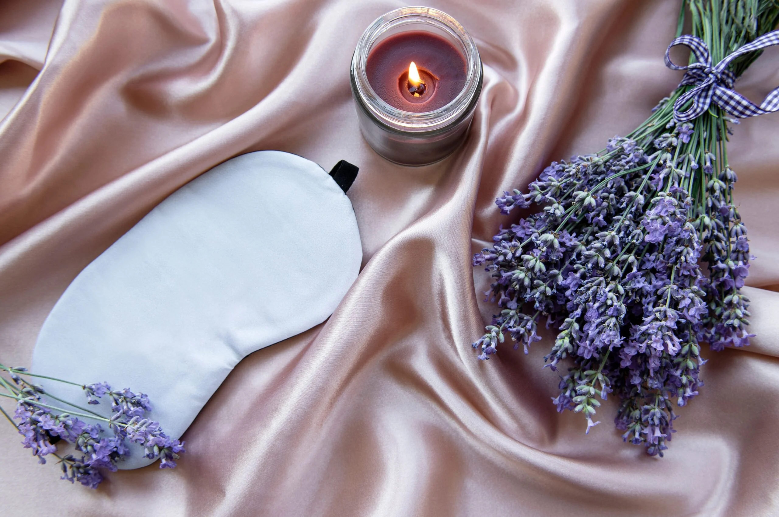 image of a sleep mask, lavender and a candle