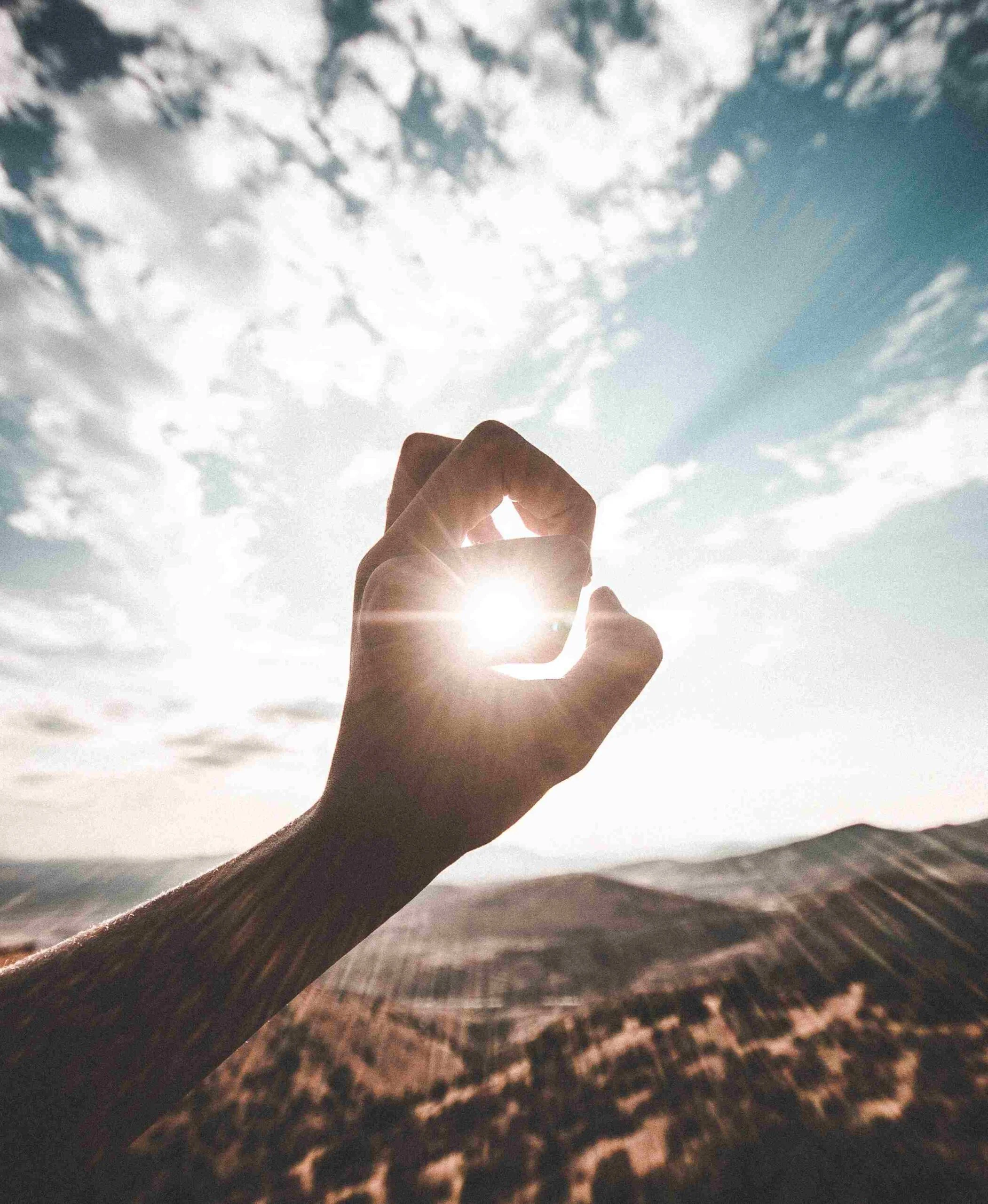 A graphic of a hand in front of the sun