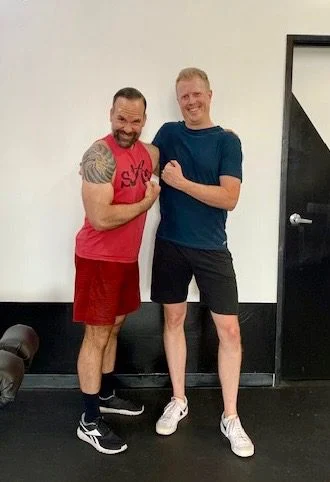 Trainer David and Jon flexing