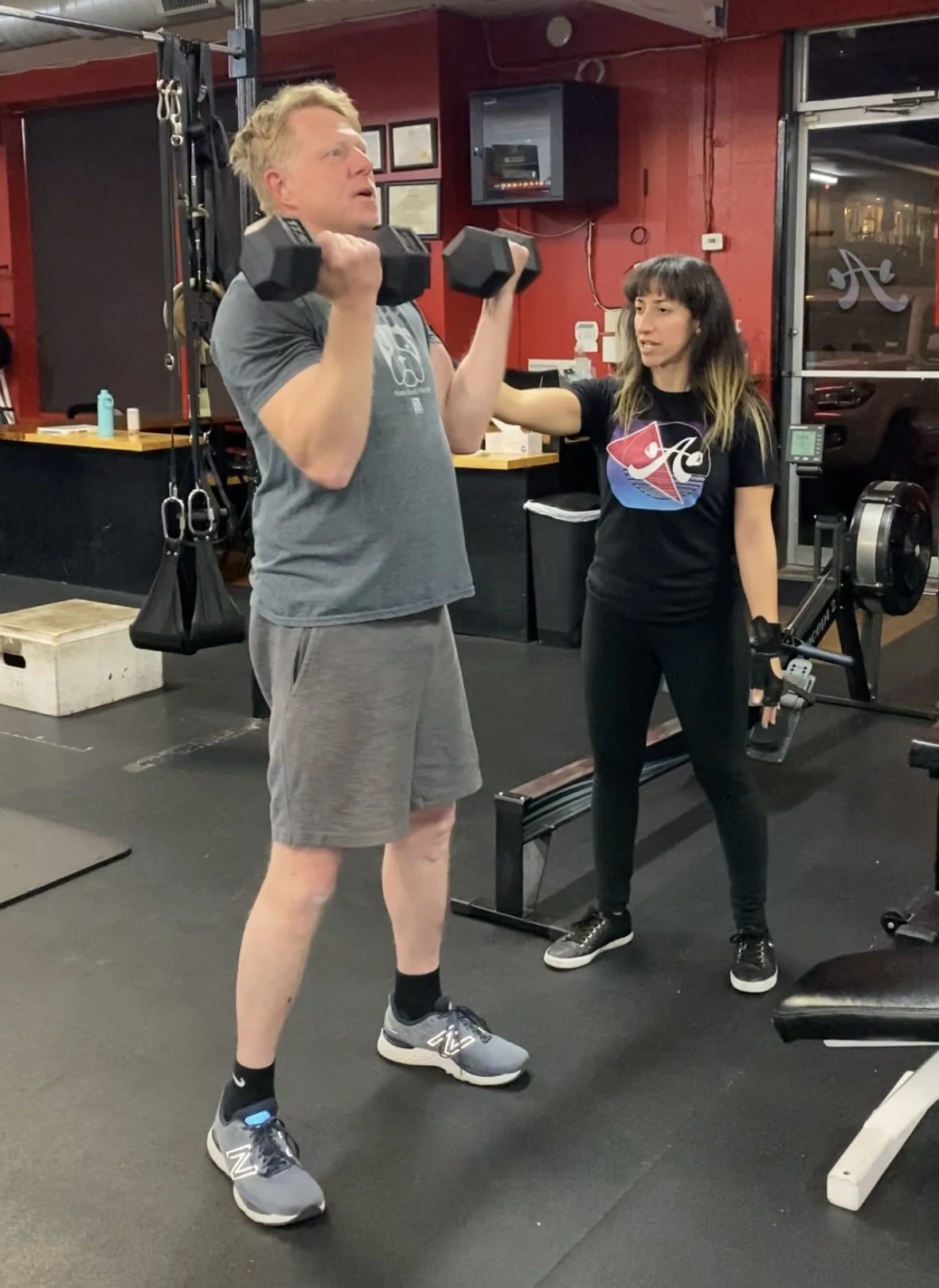Client highlight doing a biceps curl with his trainer Vilita