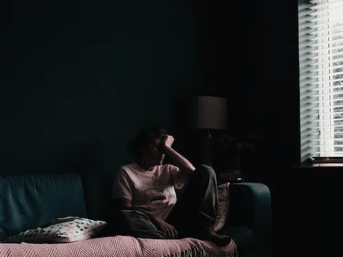 A person sitting on the couch in the dark