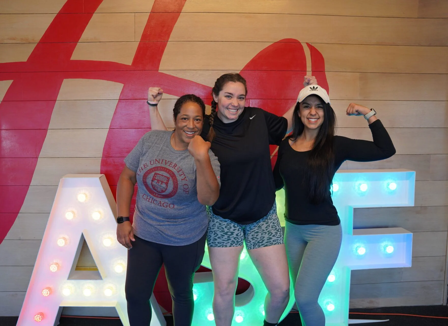Three women flexing at the Bench-A-Thon event
