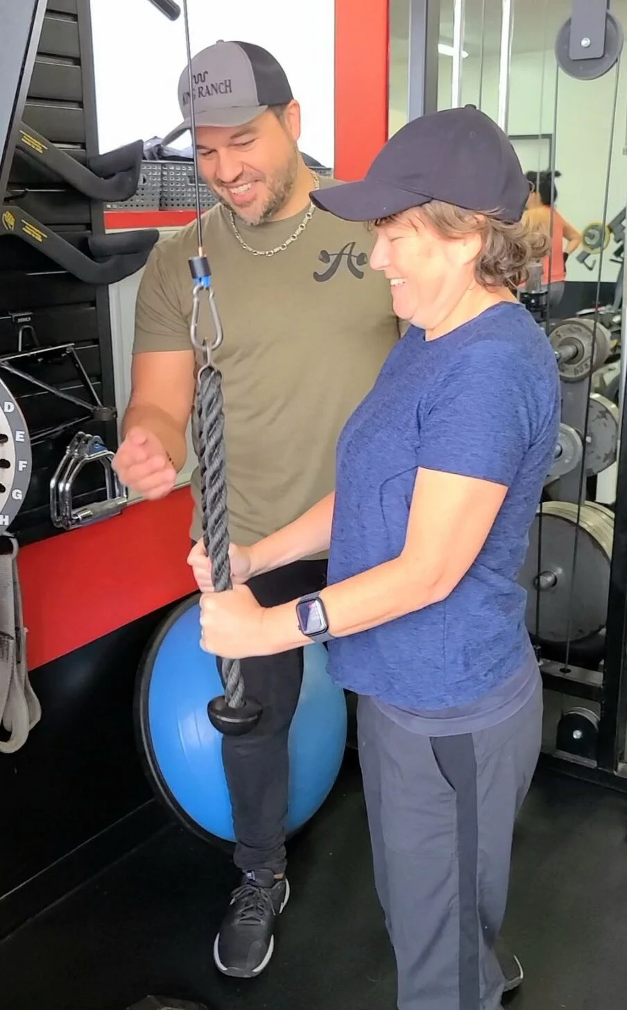 client highlight does a cable triceps extension with her trainer