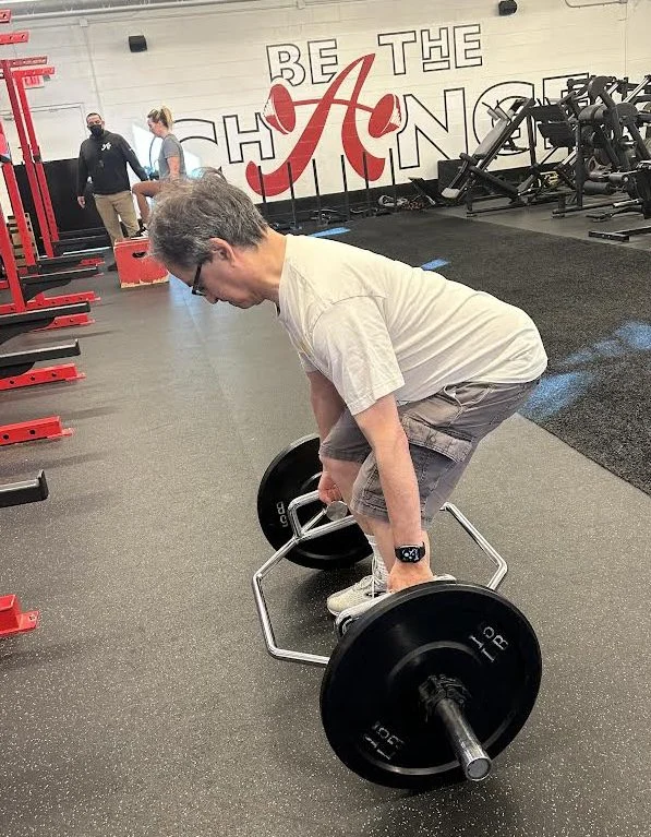 client highlight does a trap bar deadlift