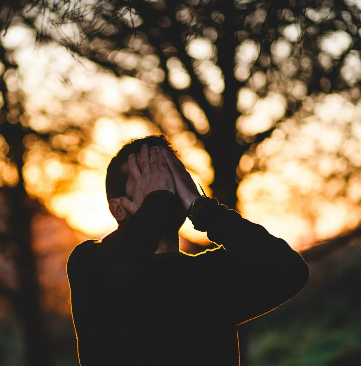 A person with their face in their hands who may have high cortisol