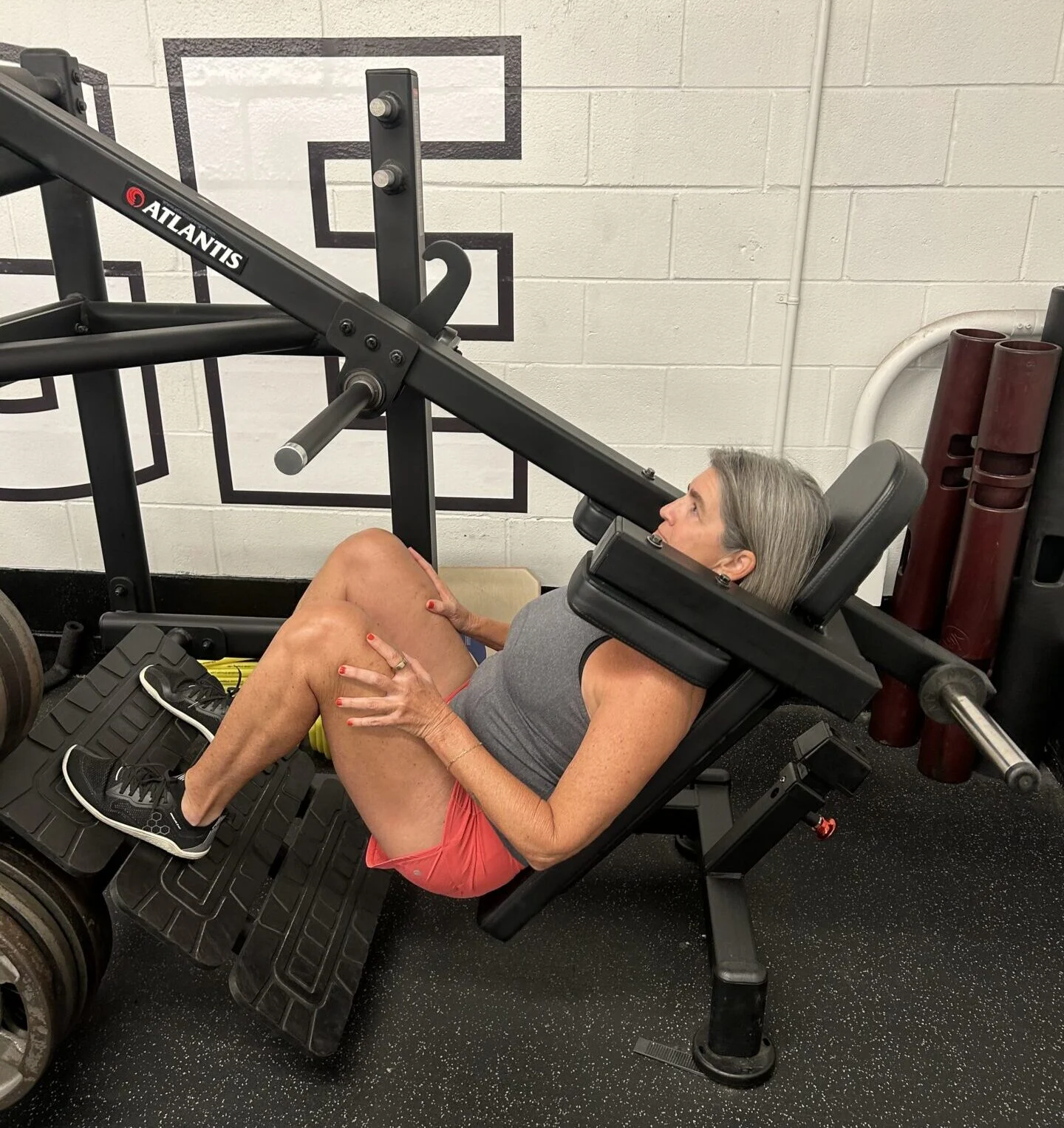 Cheryl using the pendulum squat machine