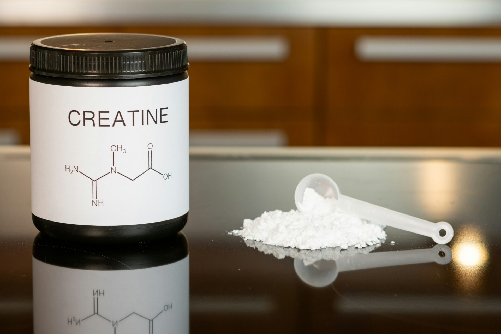 Creatine powder in a jar and on a table