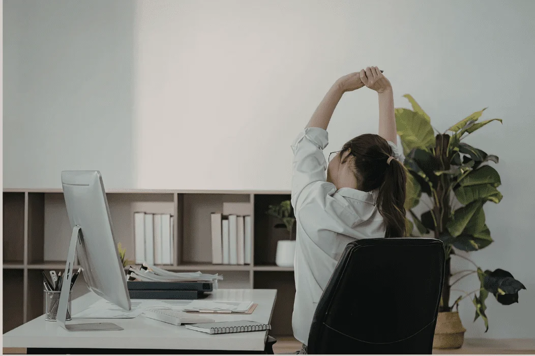 Tech professional stretching at a desk