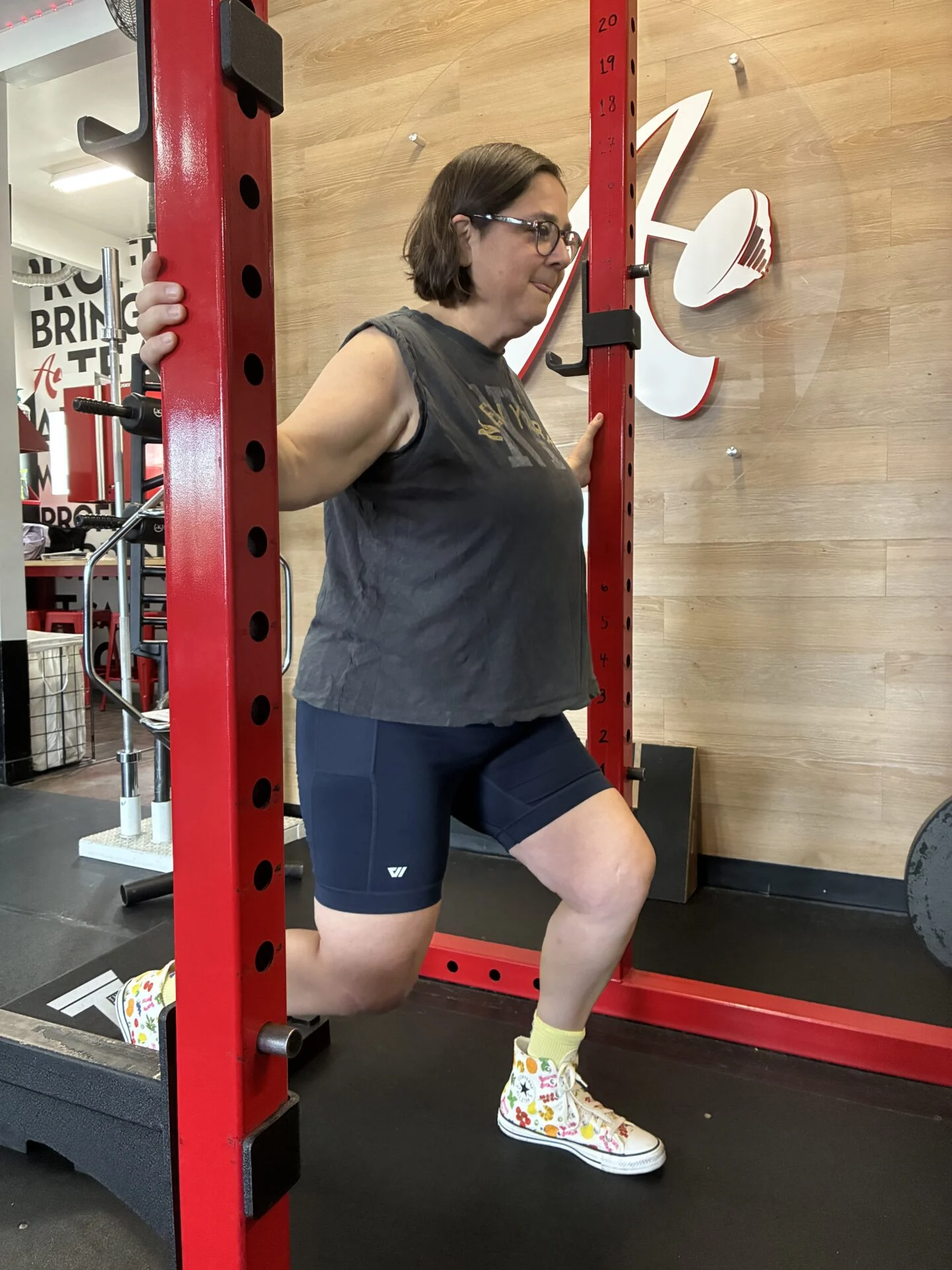Client performing split squat during weight training after knee surgery recovery