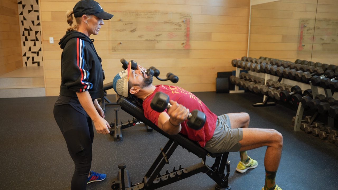 A client performs dumbbell pec flyes